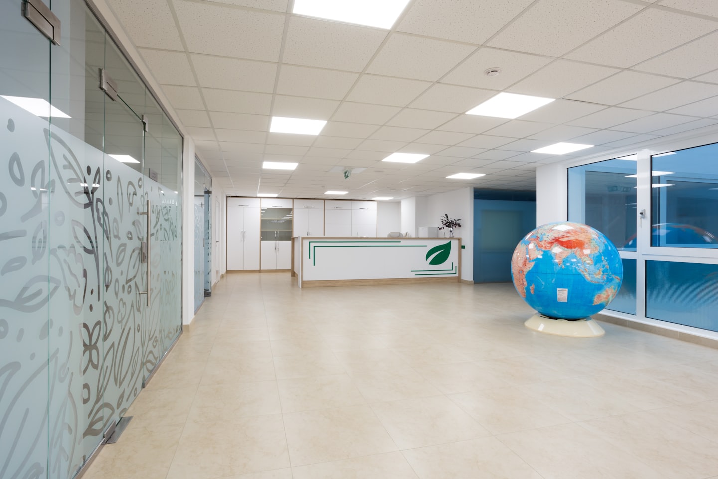 Moderna reception d'ufficio con globo e divisori in vetro satinato.